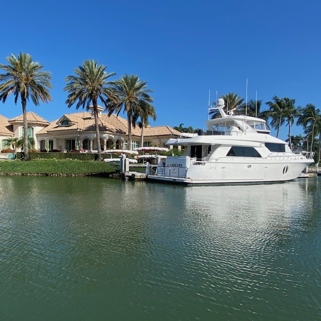 Mega-yachts and mansions along Millionaire’s Row in Naples, seen from a boat