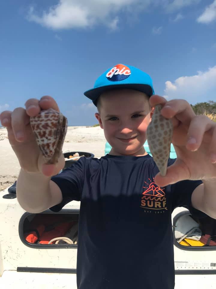 Kid Holding an Alphabet Cone and Junonia Shell
